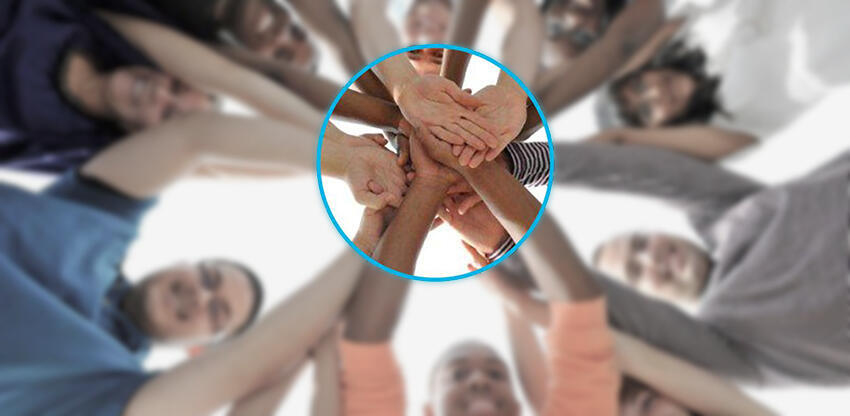 image of a circle of persons with hands together in the center